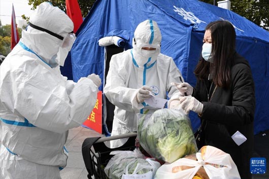 穿醫(yī)用防護服人員為大家發(fā)物資