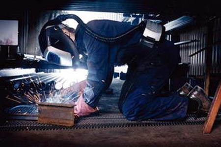 頭戴3M自動(dòng)變光電焊面罩工作的焊接員工