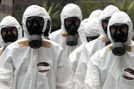 使用防毒面具，穿醫(yī)用防護服預的工作人員預防埃博拉病毒感染