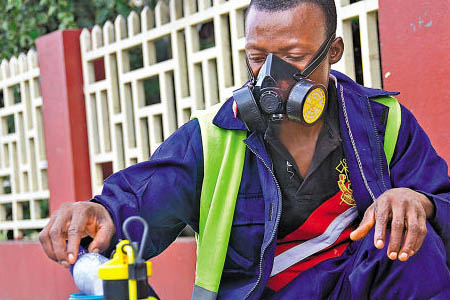 工人戴上防毒面具對(duì)化學(xué)品周轉(zhuǎn)，預(yù)防職業(yè)中毒