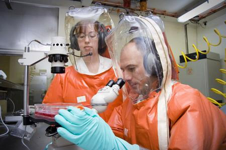 身穿全封閉防化服的生物實(shí)驗(yàn)室人員在研究