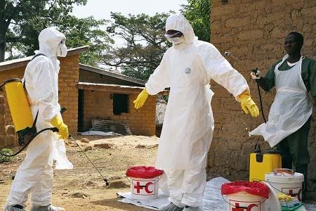 全身防護的醫(yī)護人員正在對埃博拉病毒疫情進行消毒隔離